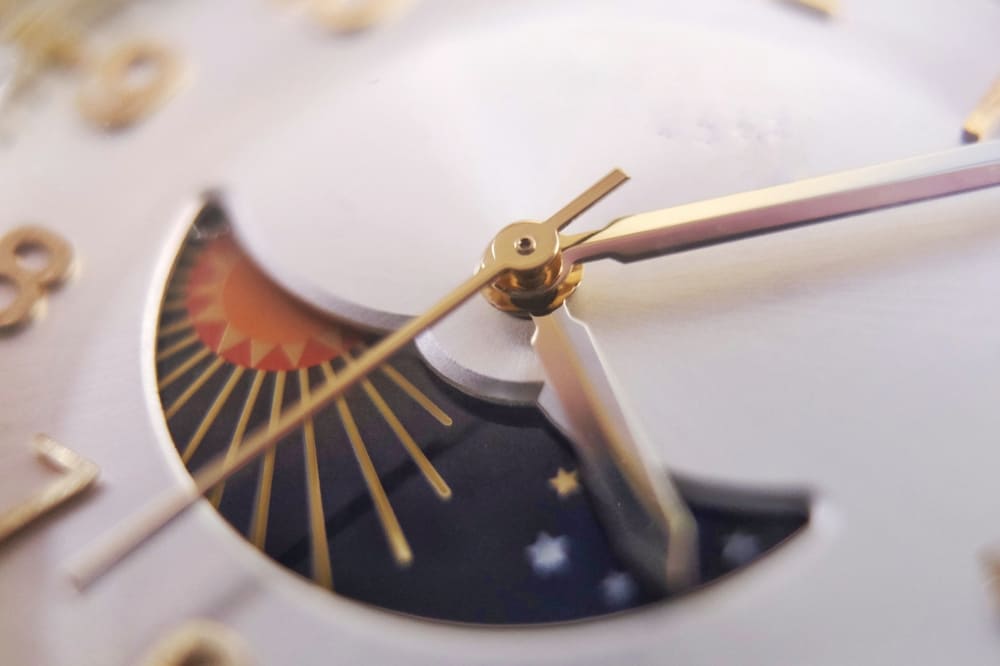 The moon phase in watchmaking: what it is and how it works Manual-winding watch with moon phase display; macro close-up of hour, minute and second hands
